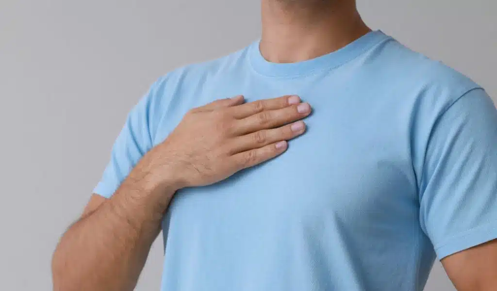 Poitrine d'un homme en teeshirt bleu qui pose sa main sur sa poitrine pour sentir sa respiration
