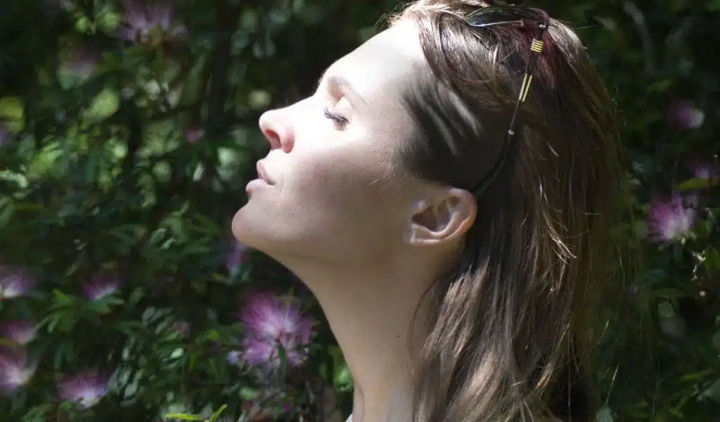 Visage d'une jeune femme qui respire dans la nature