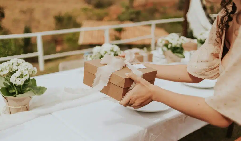 Femme offrant un cadeau lors d'un repas à table