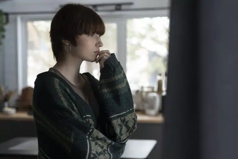 Femme pensive regardant par la fenêtre