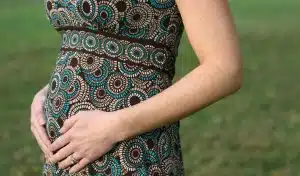 Femme enceinte tenant son ventre, en début de grossesse