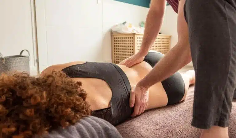 Massage au sol sur futon, personne allongée sur le côté
